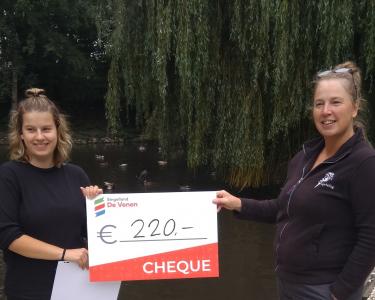 Sjanne de Boer reikt de cheque uit aan Hettie Sinnema van de Fûgelhelling Cheque Fûgelhelling